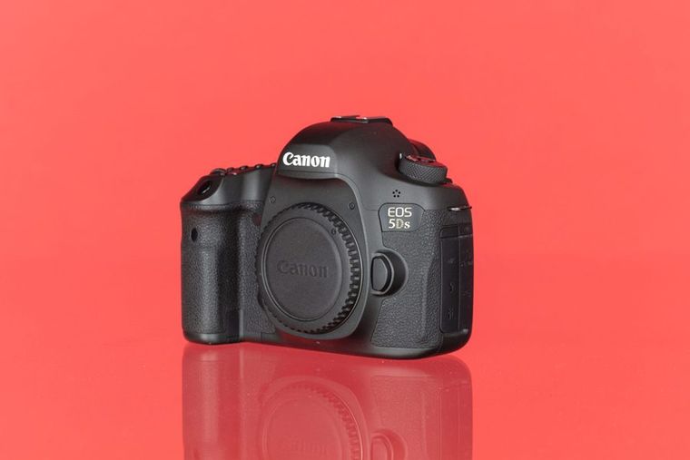 Black DSLR camera body on a red background