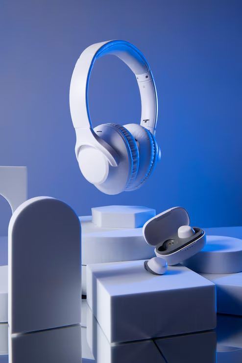 White over-ear wireless headphones on a blue display stand